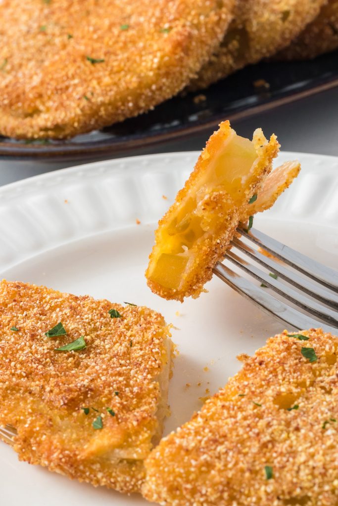 A piece of green tomato coated in cornmeal and fried.