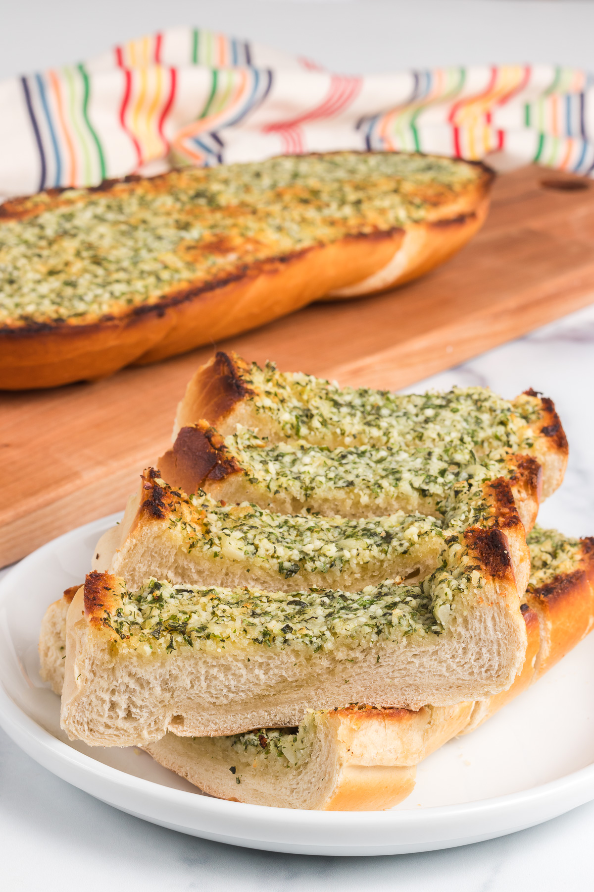 Cheesy Garlic Bread is the perfect accompaniment to any dish! Chewy Italian bread is slathered with herbed garlic butter and topped with gooey, melted cheese. Everyone will be clamoring for more! via @foodhussy