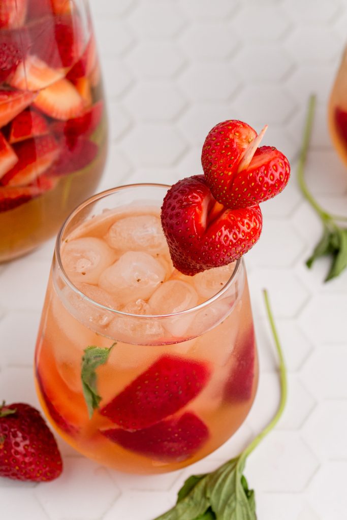 A glass of Strawberry Sangria with fresh basil.