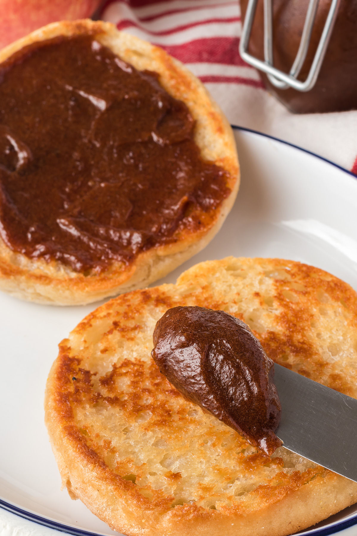 Spreading Apple Butter on an English muffin.