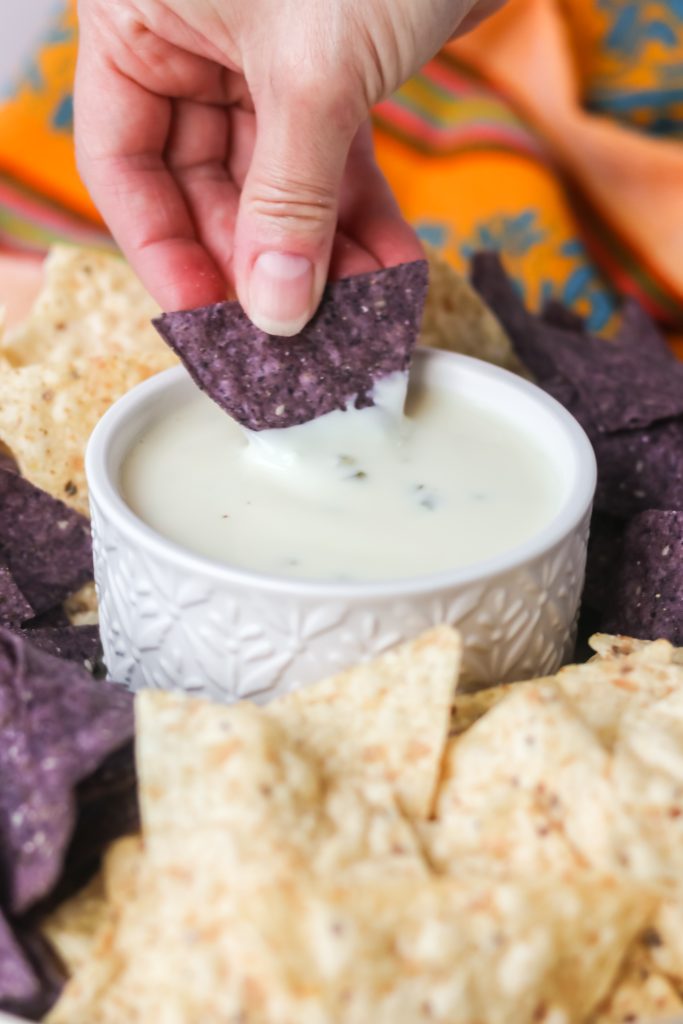 Dipping a chip into Mexican cheese dip.