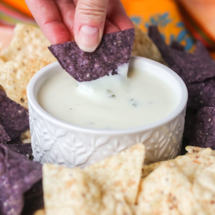 Dipping a chip into Mexican cheese dip.