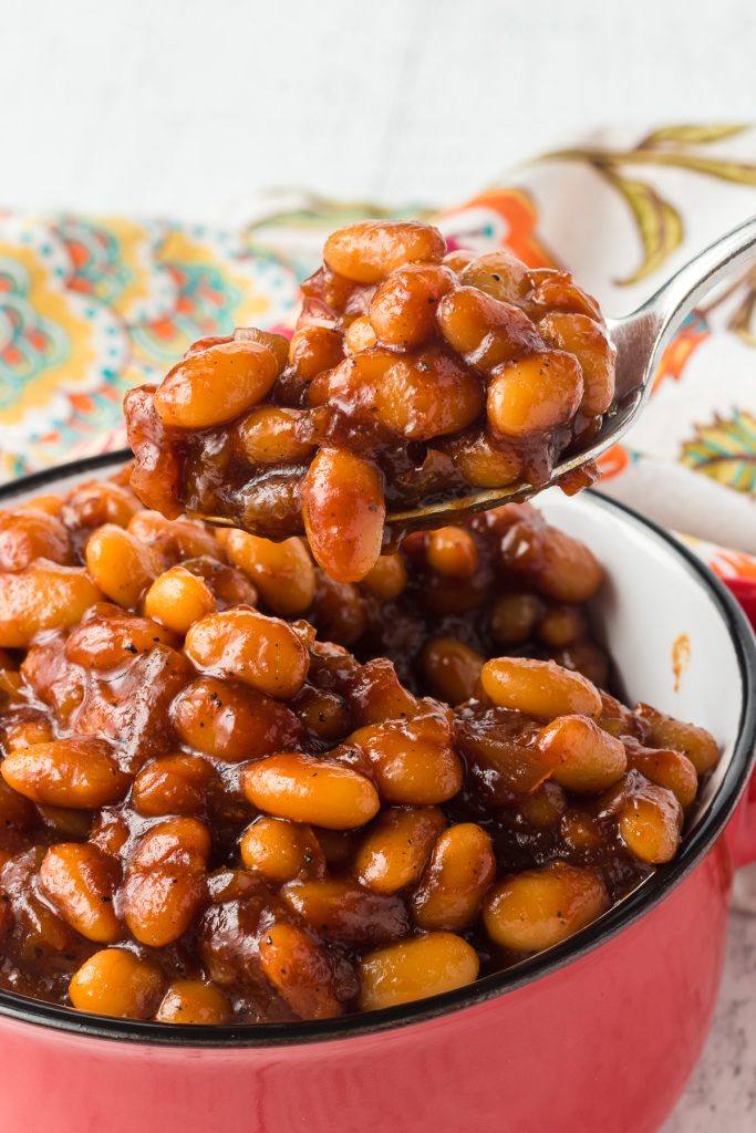 A spoonful of beans that have been baked in the oven.