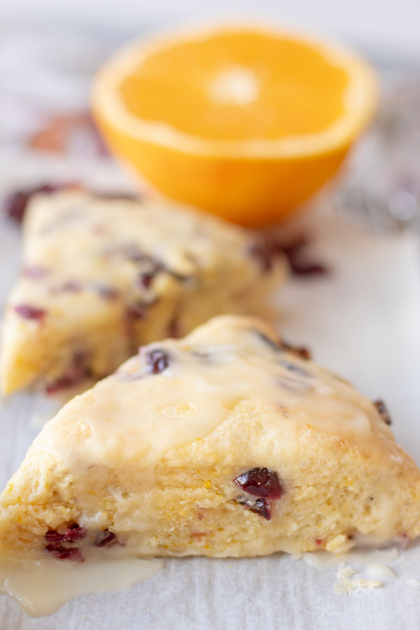 These Cranberry Orange Scones are buttery, crumbly, and light. They are full of flavor and will melt in your mouth! The tartness of the cranberries balances out the sweet orange, and they're a perfect addition for your tea or breakfast! Don’t forget the sweet orange glaze! via @foodhussy