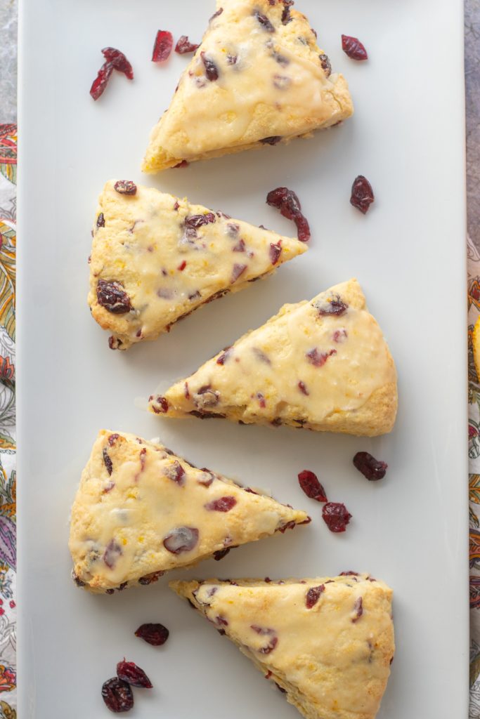 A plate of scones with orange flavor and cranberries.