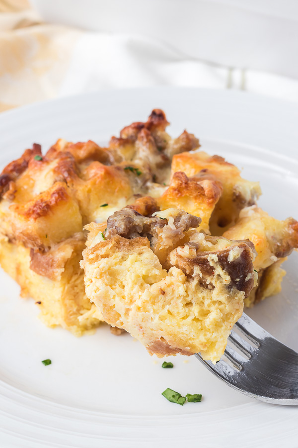 A bite of a breakfast casserole with sausage.