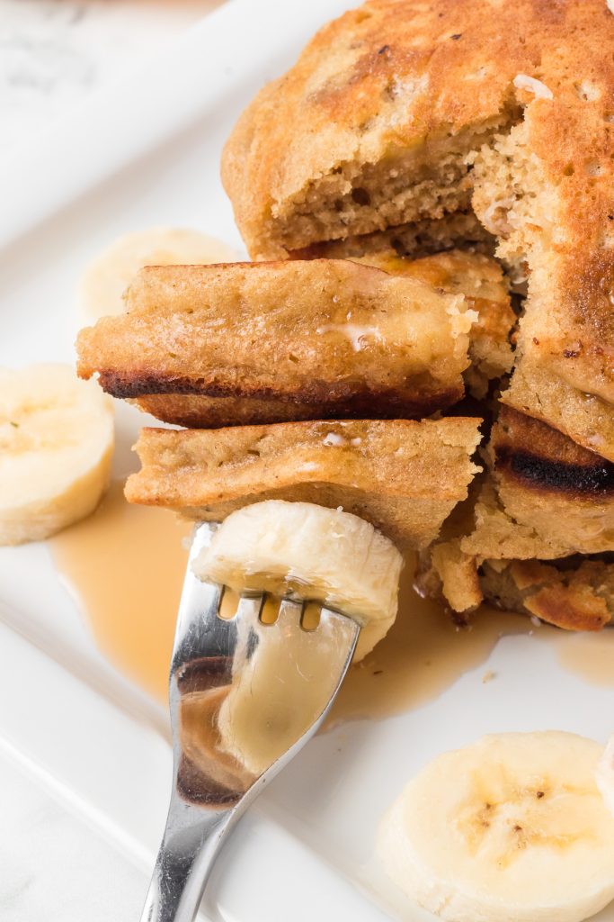 A bite of pancakes with mashed banana in them.