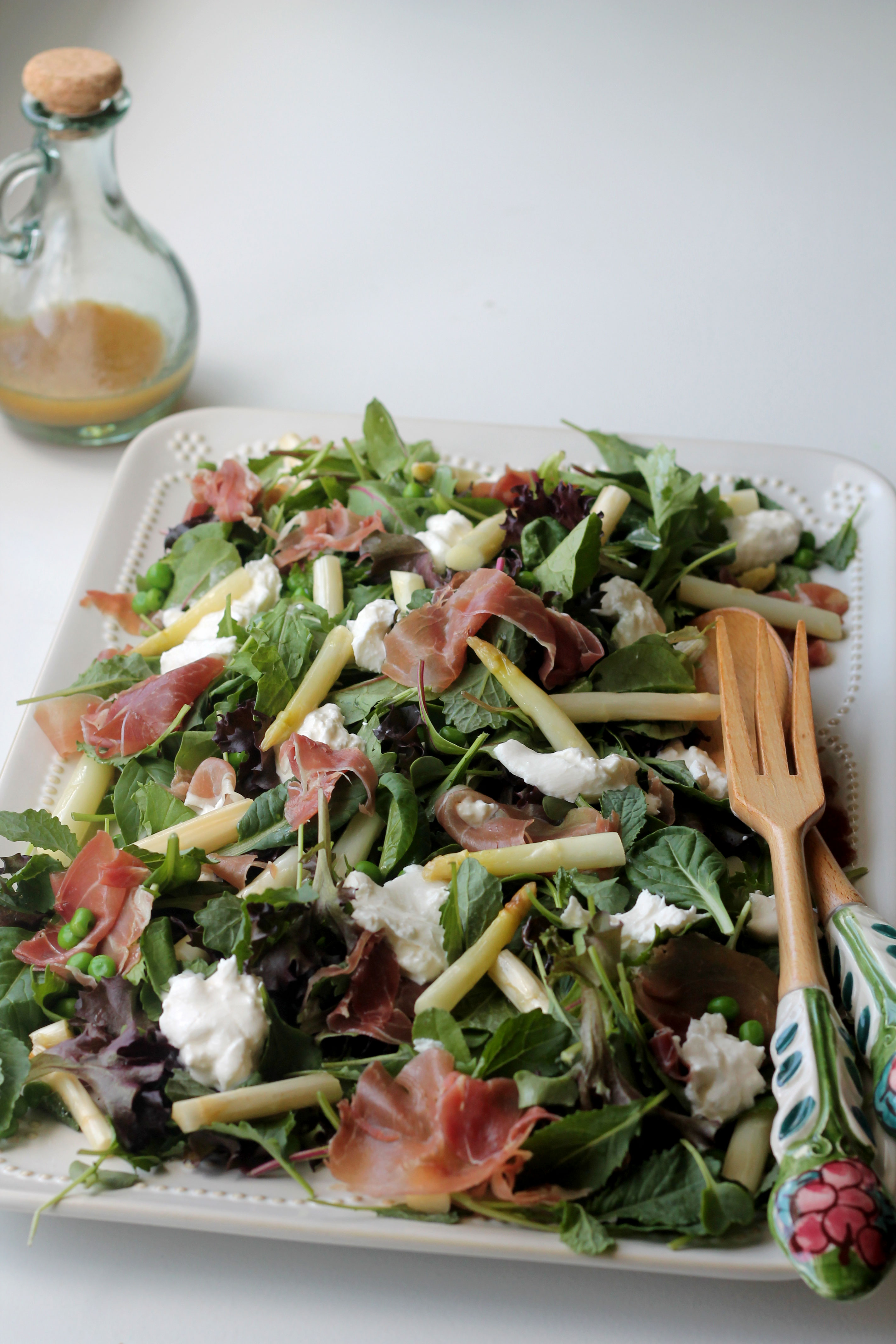 This salad will be your go to salad for the spring! It's full of Asparagus, Peas, Prosciutto and Burrata Cheese!