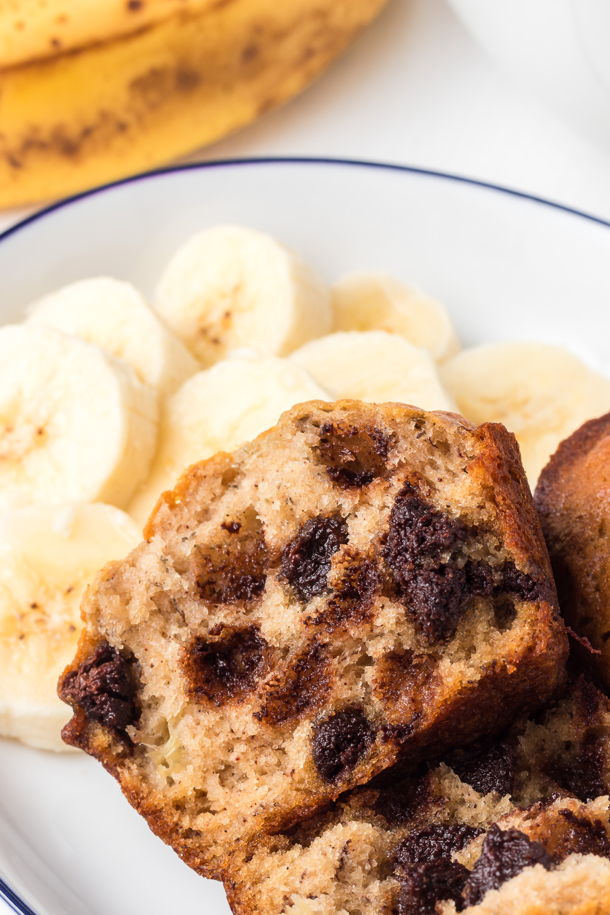 Banana Chocolate Chip Muffins are tender and sweet, with a moist crumb and milk chocolate chips that melt in your mouth with each bite! It tastes like your favorite banana bread, but bite-sized! These muffins make the perfect quick breakfast or afternoon snack! via @foodhussy