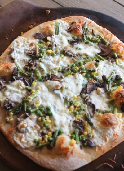 A hearty vegetarian pizza full of spring vegetables and 3 cheeses