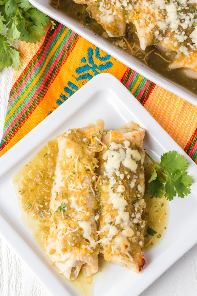 Enchiladas smothered in cheese and a tomatillo salsa.