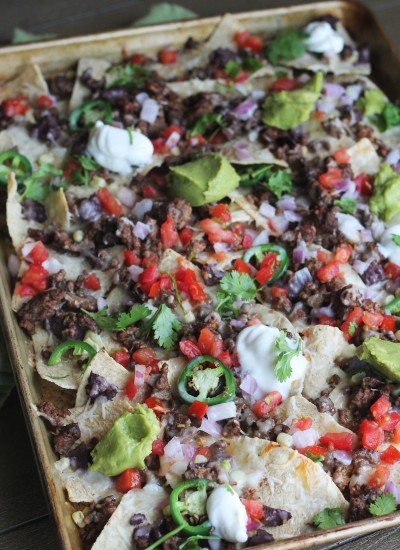 Sheet Pan Beef Nachos loaded with cheese, tomatoes, jalapenos, beans, corn, and queso