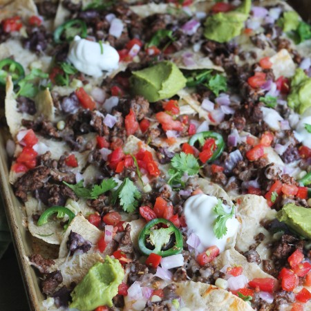 Sheet Pan Beef Nachos loaded with cheese, tomatoes, jalapenos, beans, corn, and queso