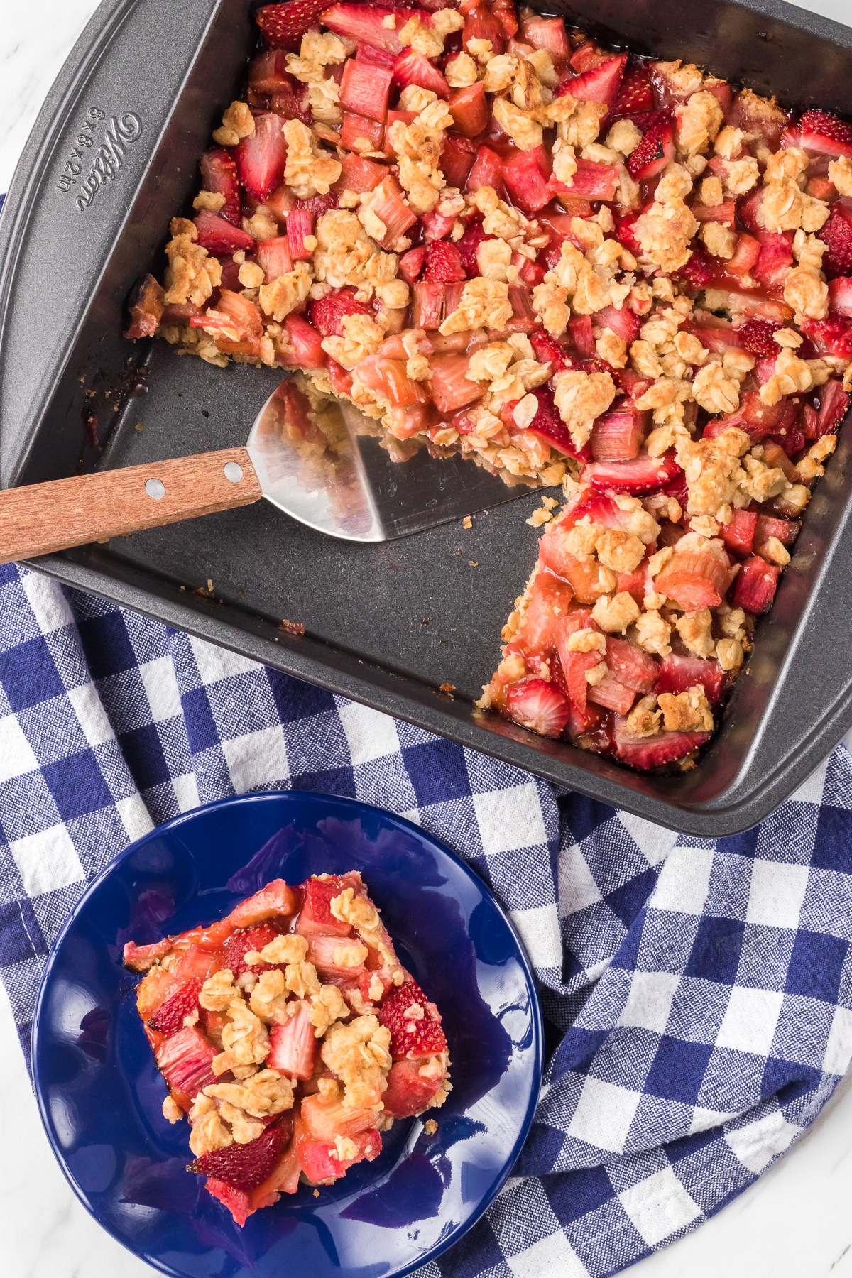 A piece of an oatmeal bar with fruit cut out of the pan.