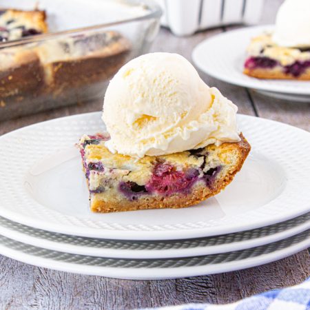 Mixed Berry Pie Bars topped with ice cream.